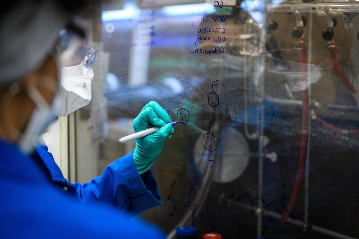 student in a lab writing