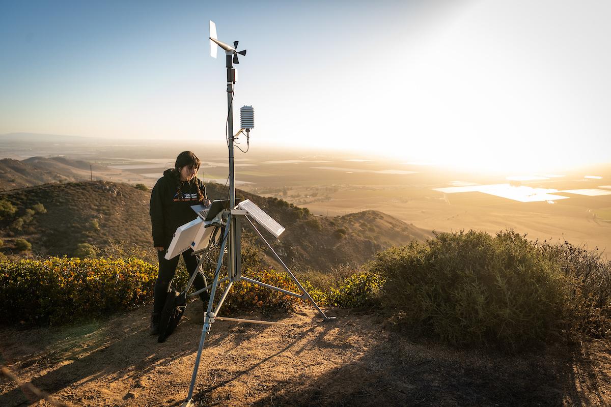 student with meterology machine at sunrise